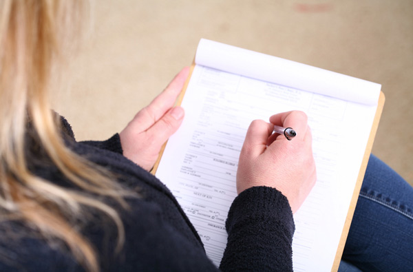 Woman filling out insurance paperwork.